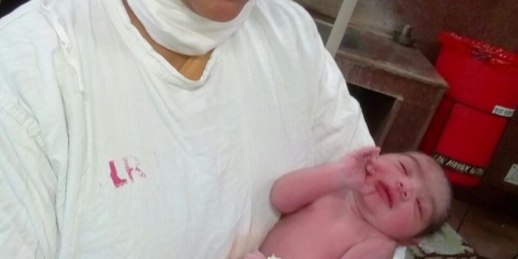 Sr. Nilam holding a newborn baby-  a part of her Nursing Training