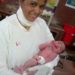 Sr. Nilam holding a newborn baby-  a part of her Nursing Training